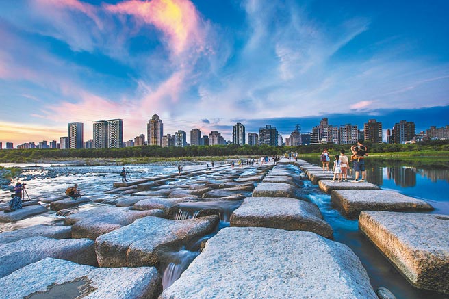 新竹头前溪豆腐岩变「豆腐乾」，吸引民眾休閒拍照打卡。（罗浚滨摄）