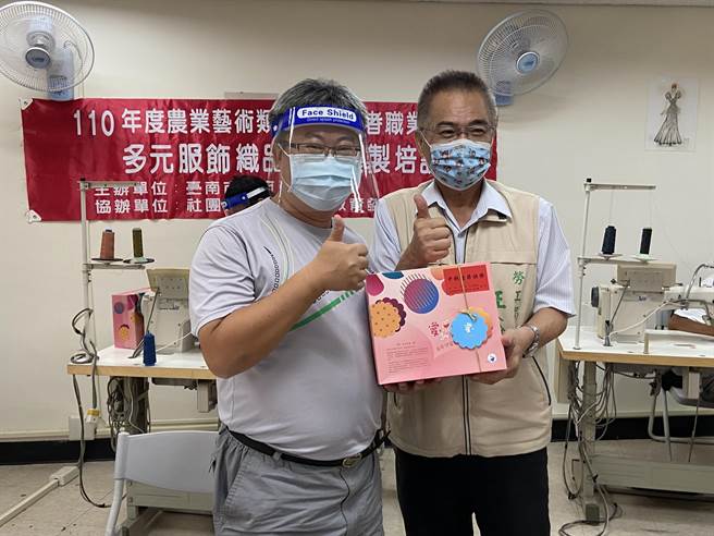 勞工局長王鑫基（右）代表市長黃偉哲致贈庇護工場的月餅給學員。（台南市勞工局提供／張毓翎台南傳真）