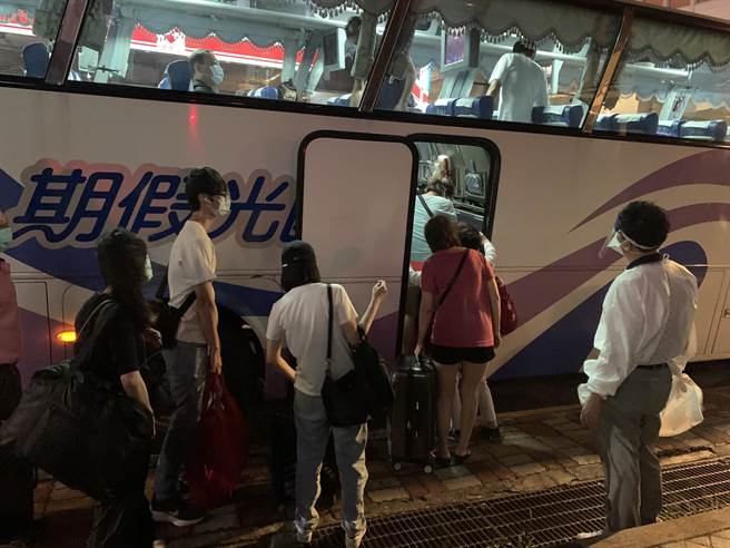 住户陆续搭乘公车前往集中检疫所。（王扬杰摄）