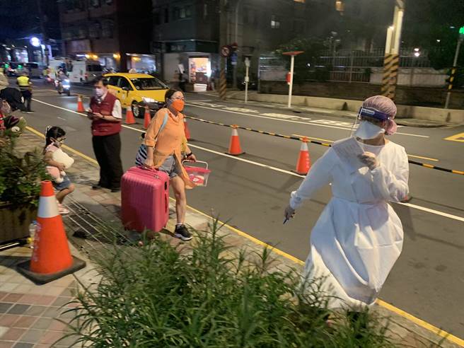 住户陆续搭乘公车前往集中检疫所。（王扬杰摄）