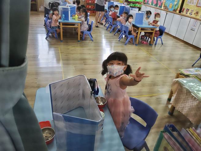 斗南镇幼儿园用资料夹当隔板，让小朋友吃点心时摆放在桌上。（周丽兰摄）