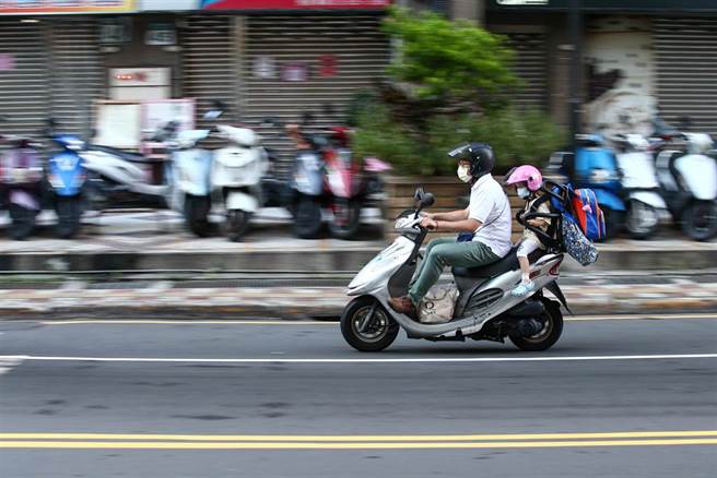 新北幼儿园群聚衍生出来的社区感染再扩大！中央流行疫情指挥中心9日公布国内新增6例COVID-19确定病例，下班时间，民眾快速经过「染疫大楼」。（邓博仁摄）
