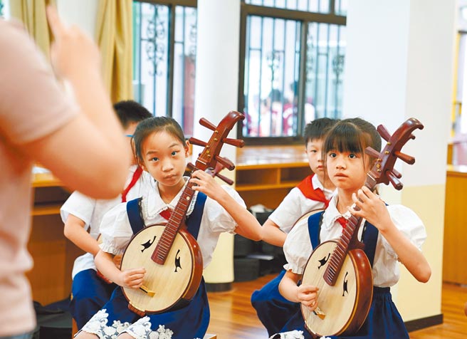 大陸禁止違規校外補習，替學生減負，學校開始吸納課後輔導功能。圖為上海黃浦區復興東路第三小學的學生們，在課後學習古琴彈奏，以解決家長無法一放學就接送的問題。（新華社）