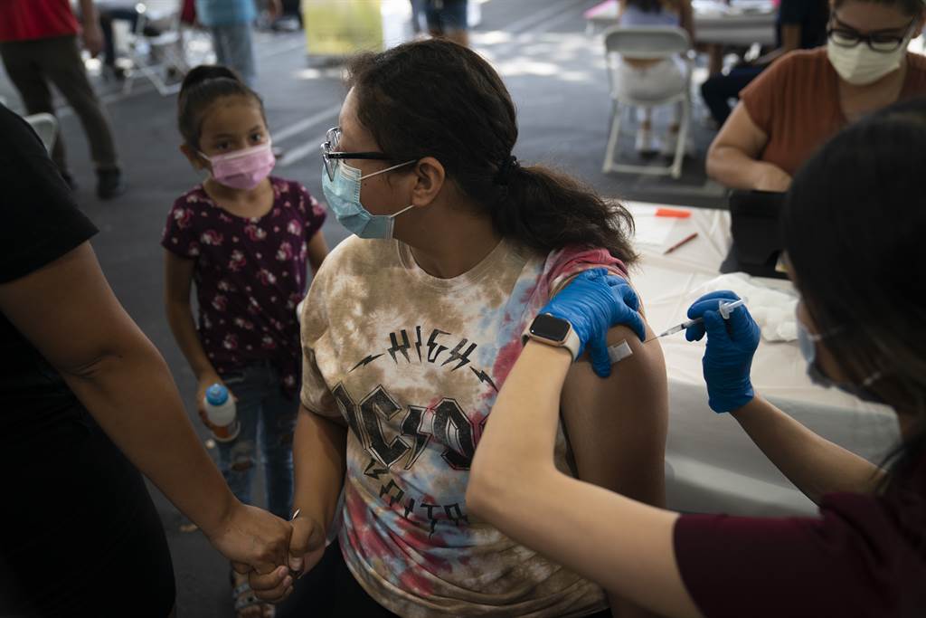 14岁的女孩在接种辉瑞疫苗时，手握母亲的手。（图／美联社）(photo:ChinaTimes)