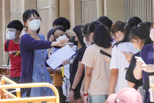 老师协助点名，安排学生筛检。（黄子明摄）