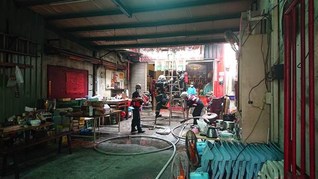 消防人员从火警民宅的隔壁小庙架梯灭火。（程炳璋摄）