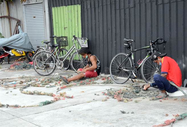 外籍渔工趁着渔船返港，来到岸上整理渔具。（林和生摄）