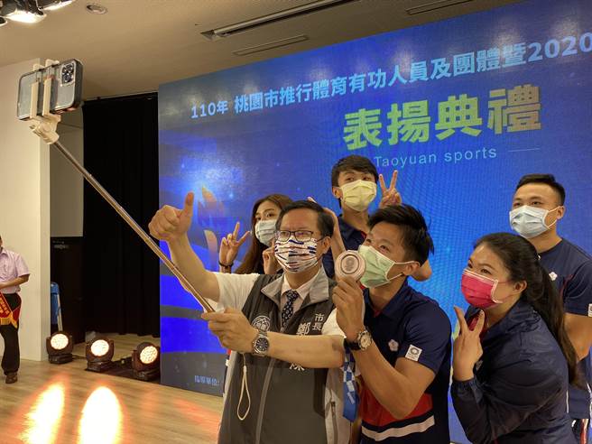 桃园市长郑文灿11日表扬代表桃园出征的东京奥运选手，共发出538万元奖励金，他也和田径郑兆村（右起）、射击田家榛、竞技体操李智凯、跆拳道黄钰仁和苏柏亚自拍合影留念。（蔡依珍摄）