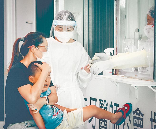 新北市府面对来势汹汹的Delta病毒採取扩大筛检，有小朋友因害怕採检忍不住大哭想挣脱，家人在一旁安抚。（罗永铭摄）