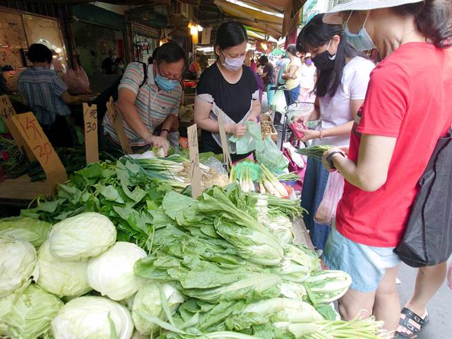傳統市場買氣熱絡，民眾選購葉菜類蔬菜。（黃世麒攝）