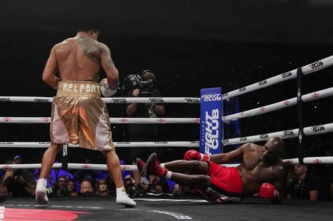 贺利菲德(右)被对手的上勾拳打倒在地。（美联社）