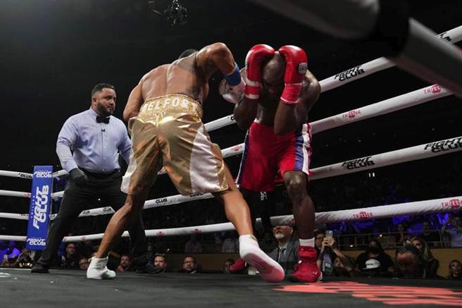 贺利菲德(右)单方面被对手狂揍，裁判因此喊停比赛。（美联社）