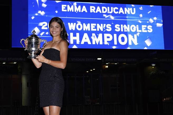 換上黑色小洋裝、略施脂粉，拉杜卡努亮麗展現自己的美網冠軍獎盃。(美聯社)
