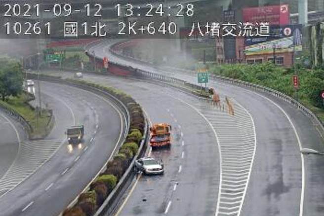 國道1號北上2.5公里處有一台銀色小客車疑似打滑擦撞中央分隔島。（摘自國道路況即時影像臉書／陳彩玲基隆傳真）