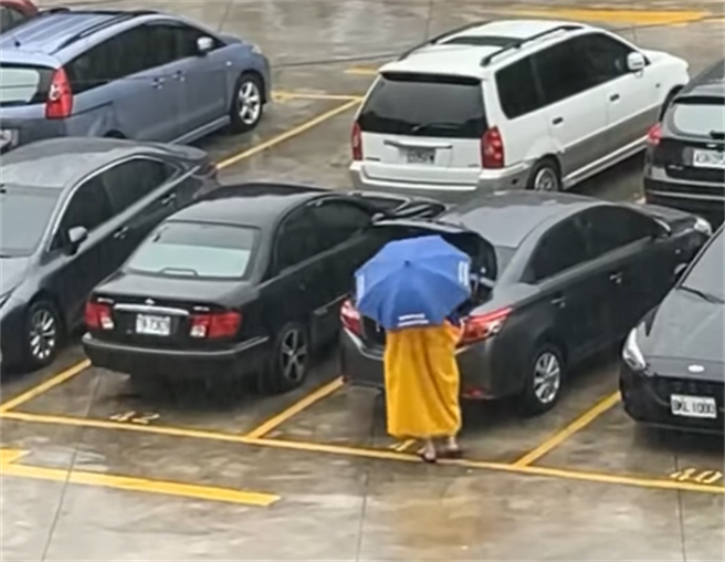 新北市汐止区崇德里里长不畏颱风，在雨天出门替里民关后车厢，引起网友热议。（翻摄脸书《汐止集团》）