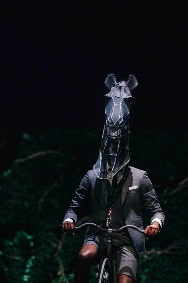 THOM BROWNE新一季以座美麗花園中心的大房子為故事背景，並由騎著古老自行車Penny Farthing、頭戴馬頭的模特開啟序幕。（THOM BROWNE提供）
