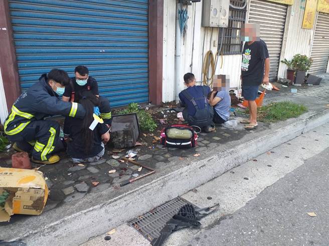 新北市八里13日一大早發生車禍，救護人員察看相關人員傷勢。（戴上容翻攝）