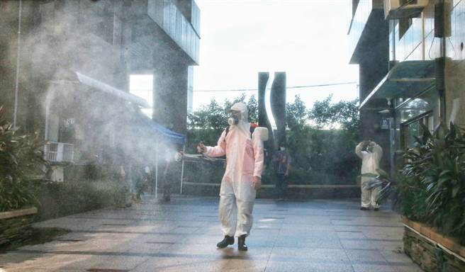 因应新北市某社区发生新冠肺炎群聚疫情，卫生福利部臺北医院医疗团队进驻社区设置接种站，13日一早工作人员进入社区消毒。（赵双杰摄）