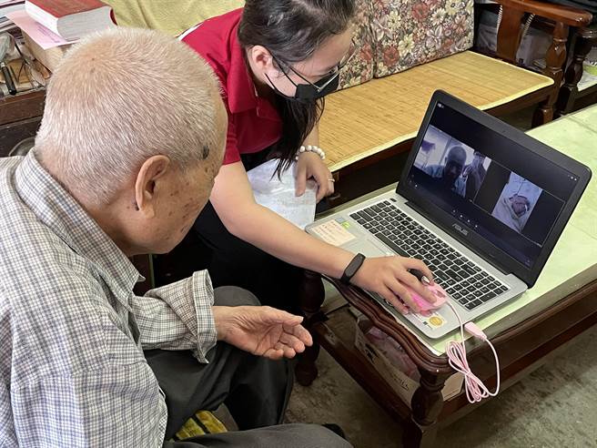 老五老石冈服务中心社工协助耿爷爷使用网路远距探视入住机构的翟伯伯。（王文吉摄）