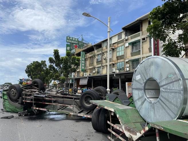 疑似钢卷掉落扯翻超大拖板车，车头压扁横躺路上吓坏高雄市民。(刘宥廷翻摄)