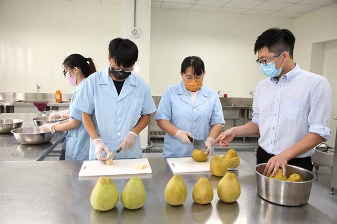 助理教授张文昌(右)研发出快速处理柑橘类水果的物理加工法，指导学生示范15秒快速剥除柚子外皮。（嘉义大学提供∕吕妍庭嘉义传真）
