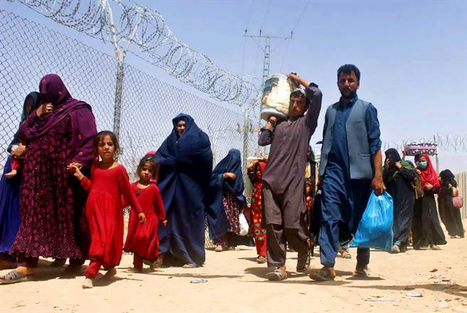 阿富汗接壤巴基斯坦的邊境城市史賓波達克（Spin Boldak）湧入數千難民，衛星畫面顯示密密麻麻的人群擠在邊界，急著想要離開。圖為阿富汗人通過巴基斯坦城市杰曼哨所的畫面。（資料照／美聯社）