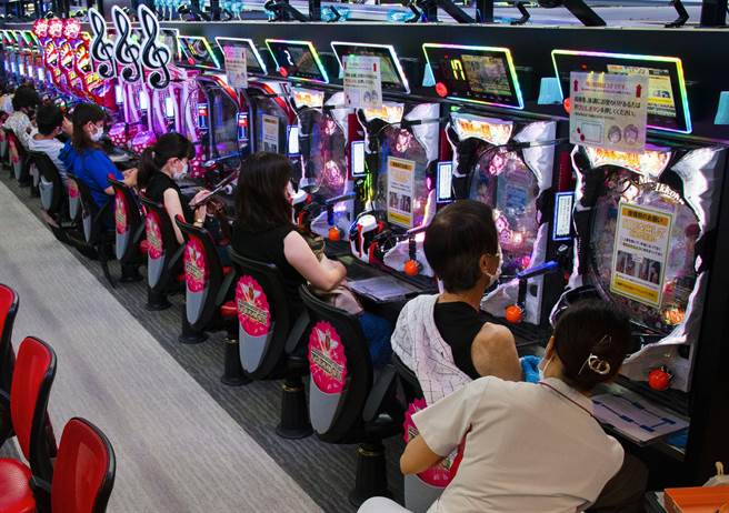 日本防疫专家认为，该国跟新冠疫情的战争至少还要持续2到3年以上。图为日本民眾于柏青哥店内接种疫苗。（图／美联社）