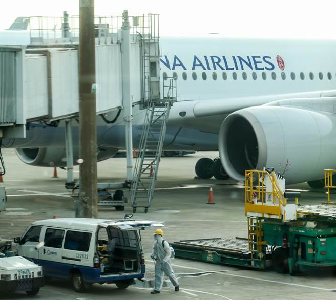 国内15日新增一例COVID-19本土个案，目前感染源待厘清，中央流行疫情指挥中心指挥官陈时中表示，本土确诊者为桃园机场负责客舱清洁人员，初步定序染Delta变异株，曾接种一剂AZ疫苗。图为桃勤清洁人员在客机停妥下客完毕后，换上防护衣，准备上机做清洁消毒工作。（非新闻当事人）（陈麒全摄）