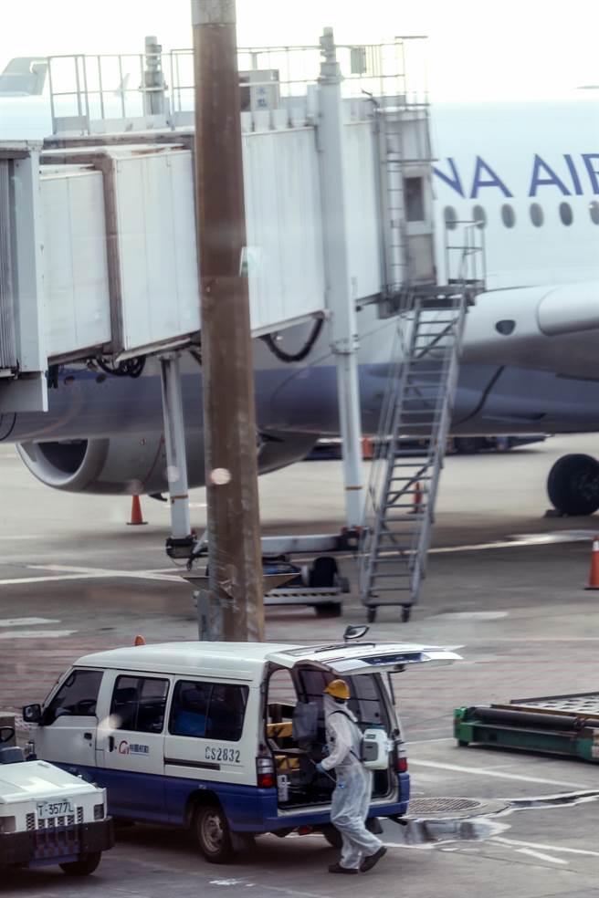 国内15日新增一例COVID-19本土个案，目前感染源待厘清，中央流行疫情指挥中心指挥官陈时中表示，本土确诊者为桃园机场负责客舱清洁人员，初步定序染Delta变异株，曾接种一剂AZ疫苗。图为桃勤清洁人员在客机停妥下客完毕后，换上防护衣，准备上机做清洁消毒工作。（非新闻当事人）（陈麒全摄）