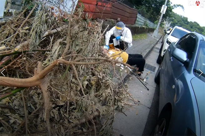 老婦人醉倒路邊，警、消協助將她送醫。（警方提供）