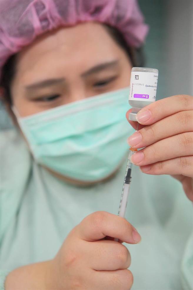 第8輪AZ疫苗開打第3天，一位醫護人員在台北科教館接種站用針管抽取AZ疫苗。（張鎧乙攝）
