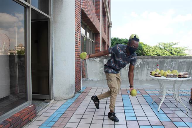 來自聖文森的羅啟信當場現學現賣製作柚子帽，第一次體驗覺得新鮮又有趣。（義守大學提供／林雅惠高雄傳真）