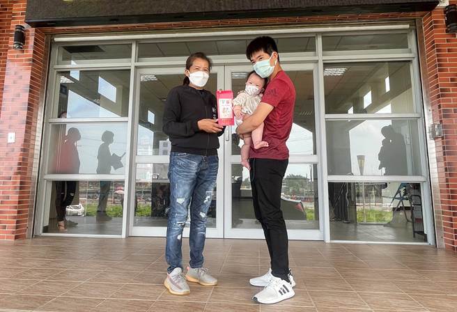 新手爸爸戴姓男子（左）從鄉長林芬瑩（左）接過新生兒禮金，他表示當爸爸後才知道養小孩很不容易，領到1萬元很有幫助，可以用來買小朋友尿褲、奶粉。（周麗蘭攝）