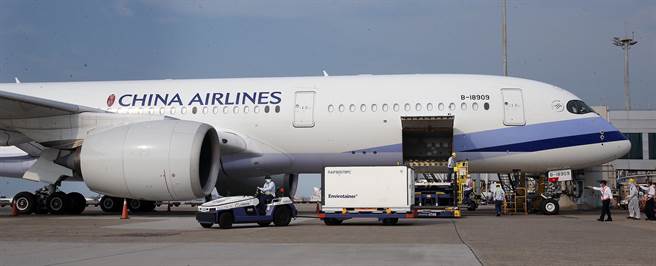 地勤人员将装载疫苗的冷冻货柜拖往仓储。（范扬光摄）