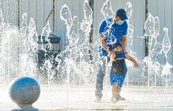 科威特首都科威特市，一名父亲带着孩子在高温天气下于喷泉里玩耍。第26届联合国气候变化大会（COP26）将于10月在苏格兰格拉斯哥举行。联合国大会下周举行期间，将召开一次世界领袖闭门会议，讨论全球暖化议题。（新华社）