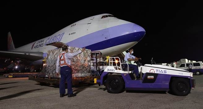 我方自购的第7批莫德纳疫苗108万剂，17日晚间由华航货机运抵桃园机场，地勤人员卸下装载疫苗的货盘后，立即拖往华储仓库。（范扬光摄）