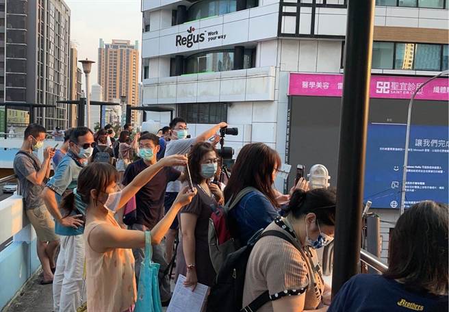 台中公益路曼哈顿悬日美景再现，大批摄影爱好者也提前至公益路与英才路口天桥上卡位等候。（冯惠宜摄）
