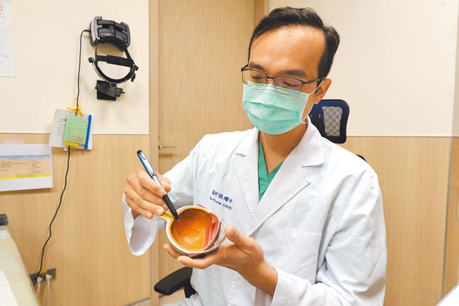 亚洲大学附属医院视网膜科主任张耀中在人体眼睛器官模型上，指出患者后玻璃体剥离位置。（林欣仪摄）
