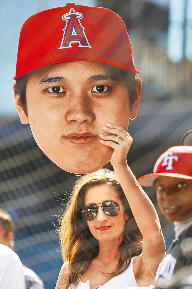 金髮美女球迷在現場高舉大谷翔平的頭像。（美聯社）