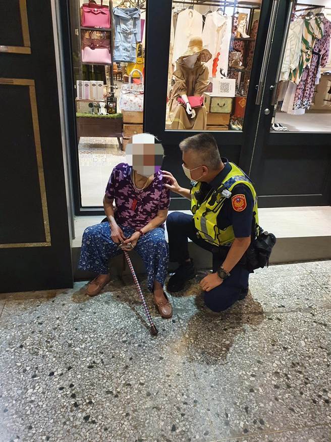 警方于大墩路服饰店前与老妪谈话，询问她家住何处？（警方提供）