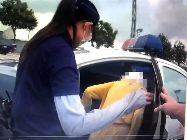 警方在車水馬龍的中山四路上發現迷途的雷姓老婦人，將她攙扶上警車。（翻攝照片／石秀華高雄傳真）