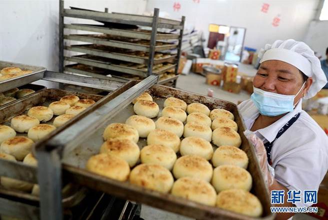 安徽省淮北市濉溪县临涣镇一老字型大小手工月饼作坊内，工作人员正忙着制作加工传统月饼。（新华社）