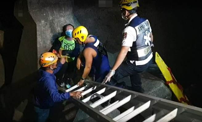 60多岁曾姓男子（左二）直接跌落在４公尺深的消波块上，经救难人员固定确保后成功救援上岸。（民眾提供／袁庭尧高雄传真）