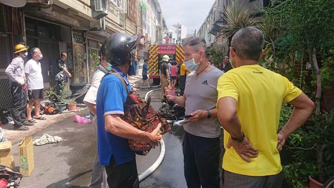 洪姓屋主怕神像受波及，衝进屋内抱着神像跑出。（程炳璋摄）