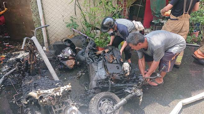 洪家女屋主看着家中杯盘狼藉，无奈请亲友协助搬起烧焦的机车。（程炳璋摄）