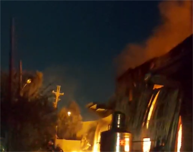 新北市林口区粉寮路二段一处铁皮工厂21日晚间发生火灾，熊熊烈火烧红夜空。（民眾提供）