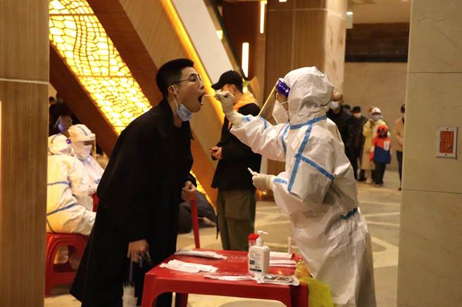 黑龍江哈爾濱，醫護人員為居民進行核酸檢測。（中新社）