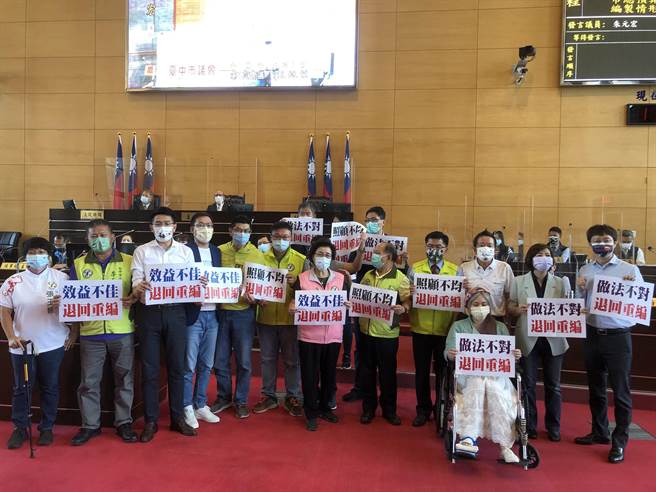 民进党团总召谢明源等走到议事堂的主席台前，高举「照顾不均、退回重编」等，要求市府将追加减预算退回重编。(陈世宗摄)