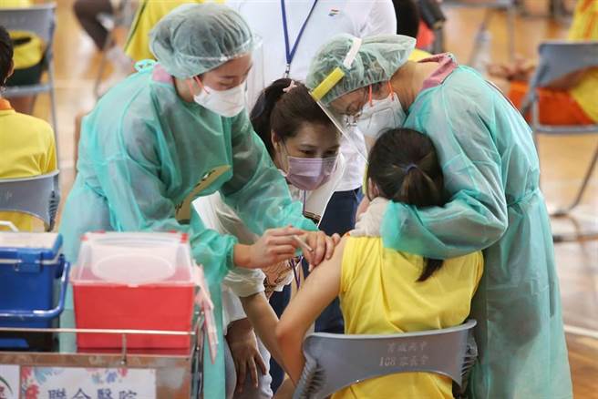 高中生22日起開始施打BNT疫苗，台北市育成高中安排動線為學生施打，老師及醫護在一旁安撫緊張的學生。（王英豪攝）