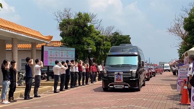 消防員、義消列隊、敬禮目送靈車離開。（張亦惠攝）